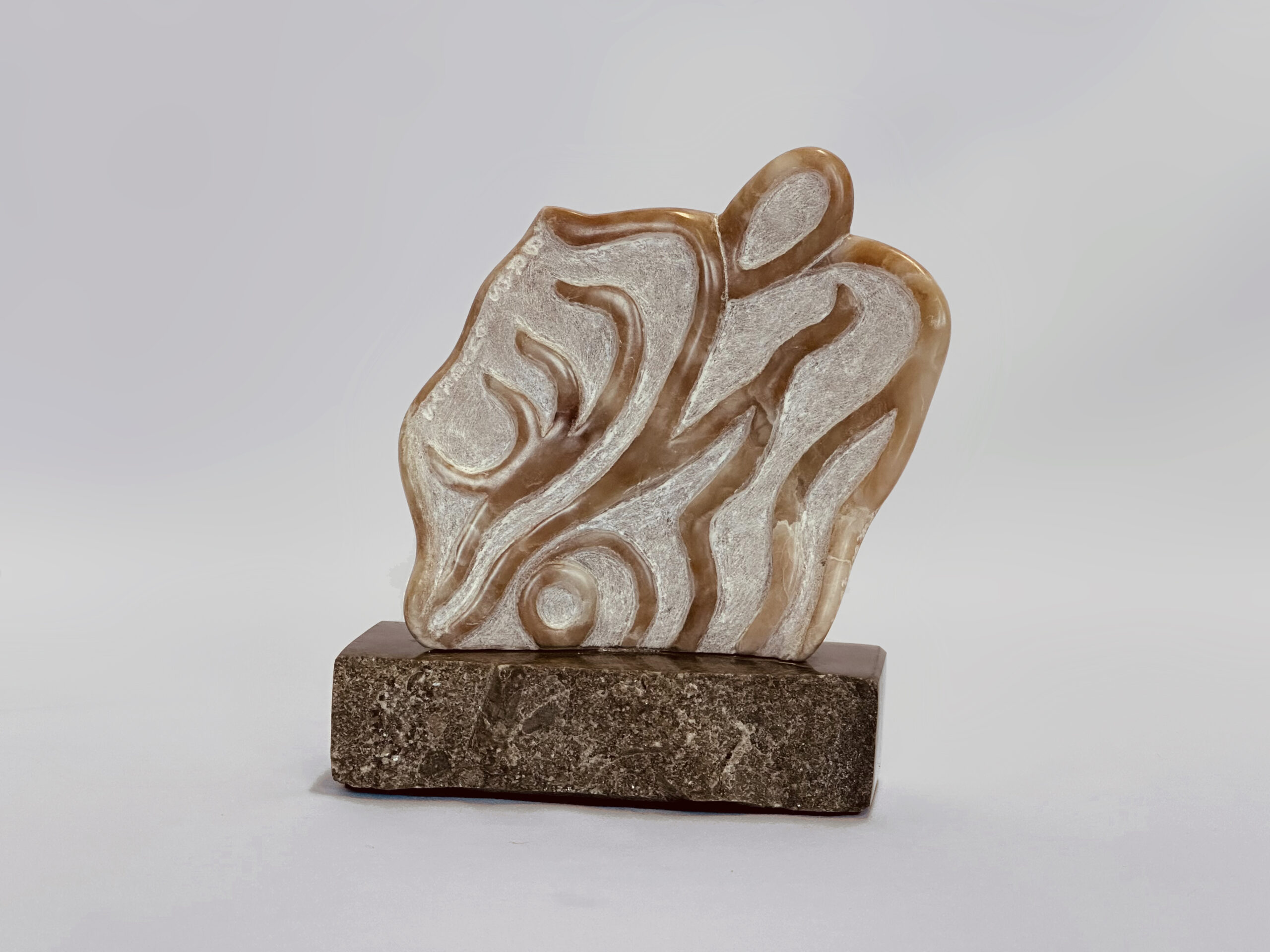 Abstract sculpture with flowing, wave-like curves in beige stone with brown veining, mounted on a dark stone base.