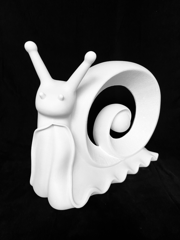 Lentement-mais-agreablement_1.jpeg White marble sculpture of a snail with an extended head and a spiraling shell.